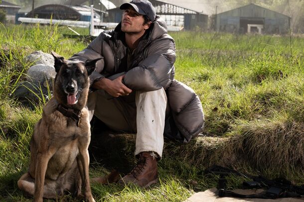 A man sitting in a field with his dog in The Dog Stars