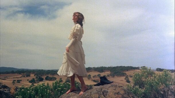 A girl in white walking on the rock in Picnic at Hanging Rock