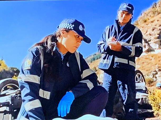 Officers examining a motorbike at the roadside in A Remarkable Place to Die
