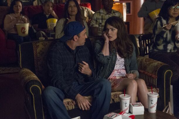 Rory and Luke side by side in a packed Stars Hollow movie theatre