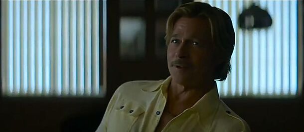 Brad Pitt as Cliff Booth in a shuttered room lit by venetian blinds