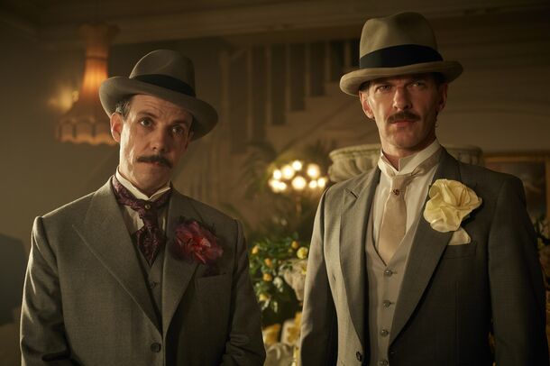 Two men in hats and grey suits at a Birmingham party in Peaky Blinders