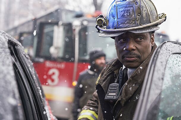 A Firehouse 51 firefighter in helmet beside the rig