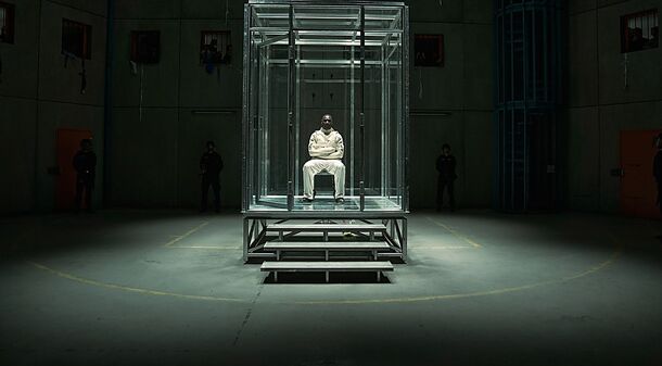Omar Sy as Assane Diop in a glass prison cell in Lupin Part 4 (2026). This part opens with Assane in prison, before he breaks out to find the copycat robbing museums in Lupin's name