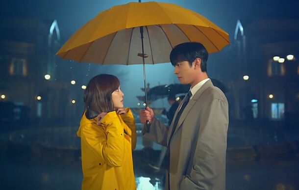 Kim Se-jeong and Ahn Hyo-seop under a yellow umbrella in Business Proposal (2022). The finale drew an 11.4% nationwide rating