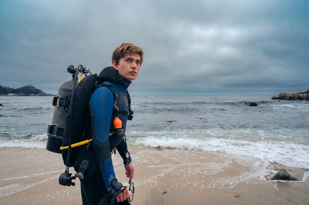 Austin Abrams as Jay Gardiner in scuba gear in Whalefall (2026). Jay is swallowed by a sperm whale and has about an hour of air to get out