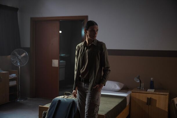 A Lioness operative stands alone in a bare motel room between assignments