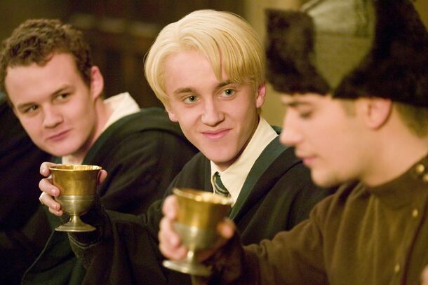 Tom Felton as Draco Malfoy raising a goblet in Harry Potter