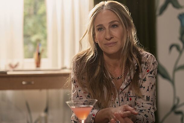 Carrie Bradshaw alone with a cocktail by the window in And Just Like That