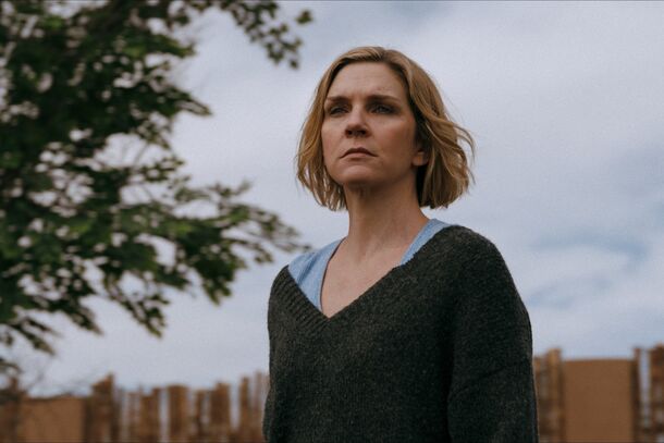 Rhea Seehorn as Carol standing outside under a tree in Pluribus