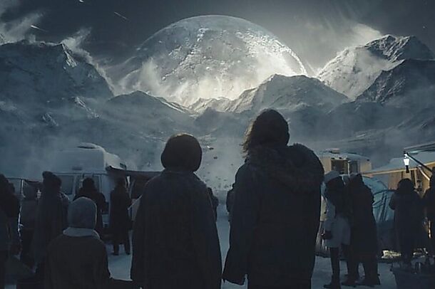 A crowd watching a huge moon rise over the mountains in Moonfall