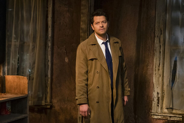 A man in a trench coat alone in an abandoned room