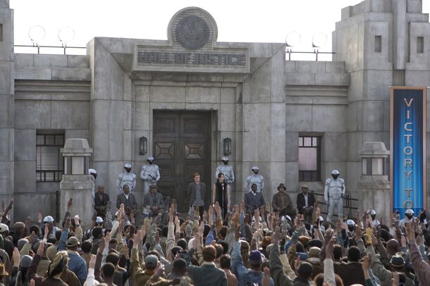 The crowd at the Justice Building during the Victory Tour in The Hunger Games: Catching Fire (2013). In District 11 an old man gives the three-finger salute and is executed in front of Katniss and Peeta