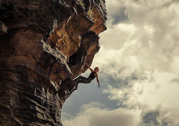 A climber on a sheer rock face in Apex (2026). Netflix cut film VP Doug Belgrad in a year when Apex and the rest of its genre slate delivered