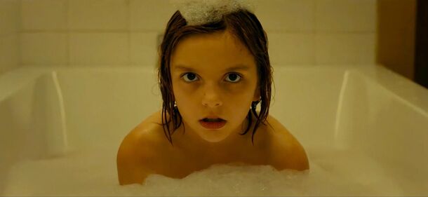 Arabella Olivia Clark as Bela in Other Mommy (2026). In the film's final confrontation, the creature comes to Bela in the bathroom wearing her own face