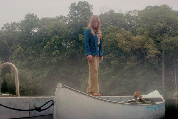 A woman stands on a canoe in the mist in Crystal Lake (2026). All eight episodes of the Friday the 13th prequel landed on Peacock on October 15
