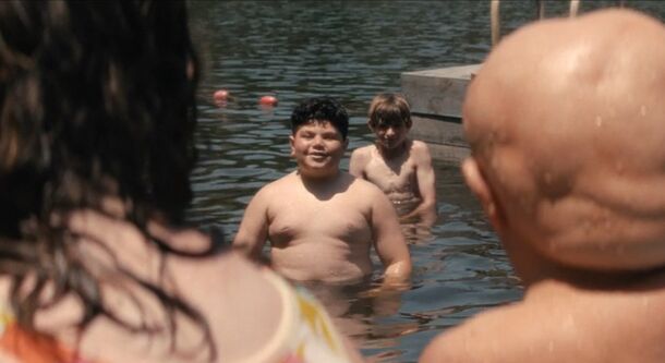 Young Jason watches other children swim in Crystal Lake (2026). The series traces his deformity to Bellflower Chemical's treatments, which started before he was born