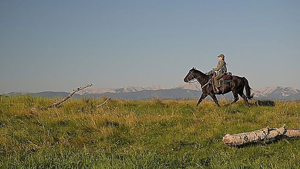 A ranger on horseback in a meadow in Anna Pigeon (2026). The series moved Nevada Barr's stories from Texas to Glacier National Park and filmed them in Alberta